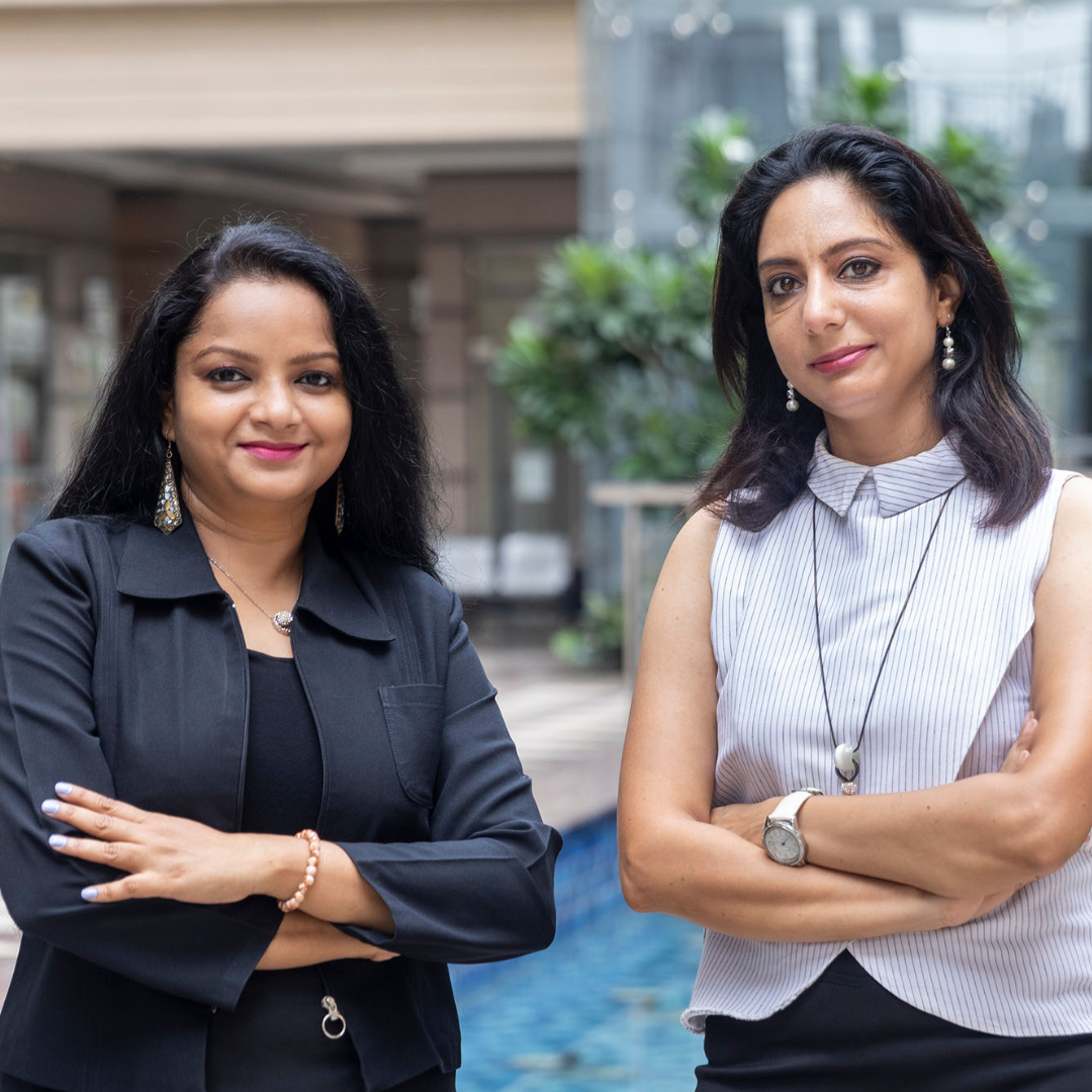 Two indian female business executives standing outside in front of office building. CMO and CEO
